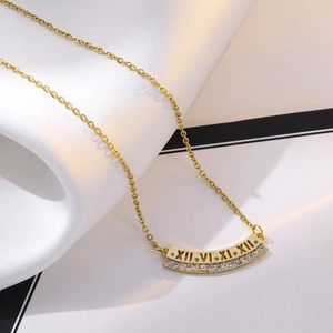 Detail of gold heart pendant with Roman numeral engraving and sparkling crystals
