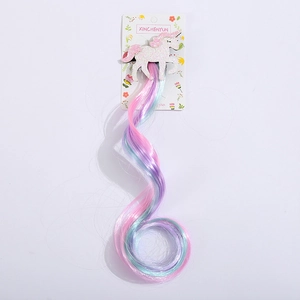 Détail d'une pince à cheveux licorne avec corne scintillante et extension bouclée colorée