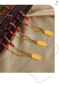 Detailed close-up of multi-colored natural stone bead necklace with a gold Caishen pendant