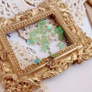 Detailed macro view of mint green aurora butterfly earrings on white lace background