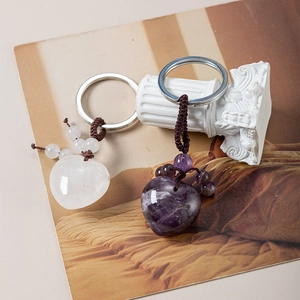 Close-up of heart-shaped amethyst and quartz crystals on woven cord keychains