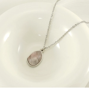 Detail view of water-drop pink crystal pendant on silver stainless steel necklace