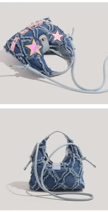 Detail of blue denim shoulder bags with pink star patches and distressed fringe edges