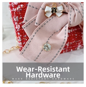 Close-up of red tweed girl bag with pink bow, camellia charm, and golden chain detail