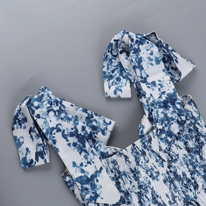 Détail de robe d'été à fleurs bleues avec bretelles à nouer et corsage froncé chic