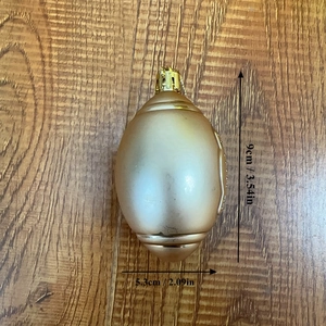 Detail view of 9cm golden rugby-shaped Christmas ball ornament with size dimensions