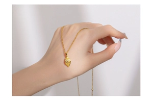 Macro shot of gold leaf pendant necklace with micro-set white zircon details on fine chain