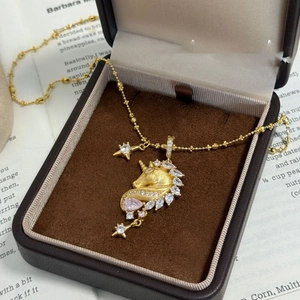 Detail of 18k gold plated unicorn pendant with pink zircon in a luxury jewelry box
