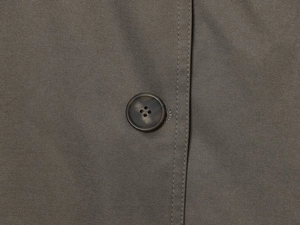Close-up of charcoal grey twill fabric and premium resin four-hole button detail
