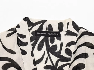 Close-up of printed kimono neckline with textured linen fabric and size tag details