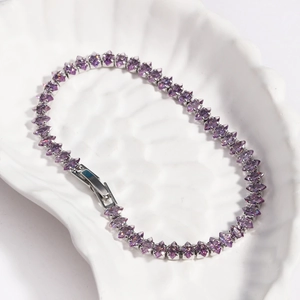 Macro detail of marquise-cut purple zircon stones set in a silver tennis bracelet