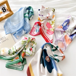 Elegant 70cm square silk scarves in diverse floral and striped patterns on white fabric
