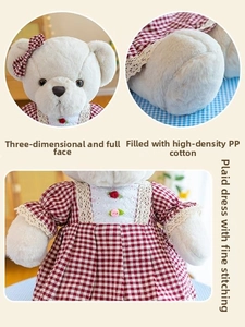 Detail of teddy bear in plaid dress showing fine stitching and soft lace trim texture