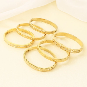 Detail of six 18K gold plated stainless steel bangles with diamond and floral patterns