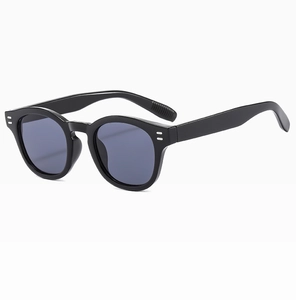 Detail of black oval sunglasses with double rivets and textured wave tips on temples