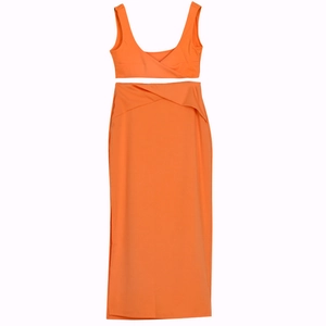 Close-up of vibrant orange two-piece set featuring a V-neck crop top and high waist maxi skirt