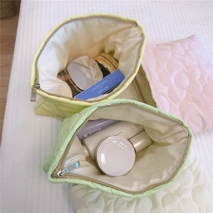Detailed view of open floral quilted makeup bags with soft texture and metal zippers