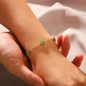 18K gold plated stainless steel bracelet with green zircon gemstones on silk background