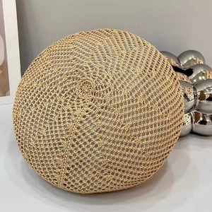 Detail of a beige woven beret featuring a spiral crochet pattern and breathable texture