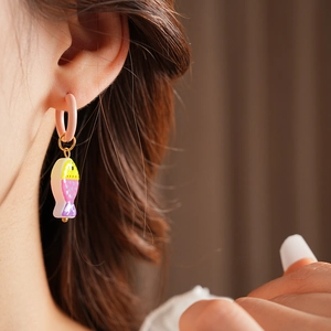 Close-up of model wearing cute pink fish earrings made of titanium steel with enamel