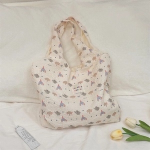 Detail of cream tote bag with elephant prints and sozakka beauté label on soft fabric