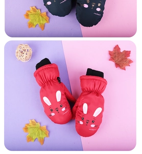 Detail view of red winter mittens for kids featuring a cute cartoon rabbit and warm cuffs