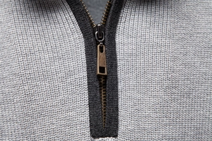 Macro detail of high-quality knit texture and vintage bronze metal zipper on men sweater