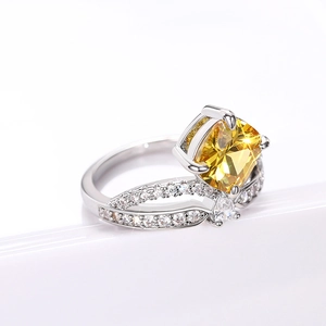 Macro-opname van kroonring met kussengeslepen gele edelsteen en micro-pave zirkonia