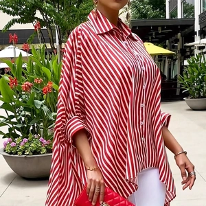Detail of red and white striped oversized long-sleeve shirt with an irregular hem design