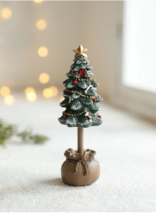 Macro detail of mini green Christmas tree with white snow coating and gold star topper