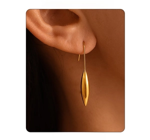 Close-up of elegant gold water drop earrings worn by a model in a minimalist style