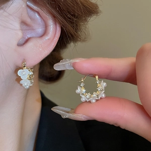 Elegant gold flower hoop earrings with white petals, pearls, and sparkling crystals