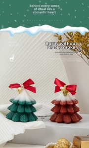 Close-up of red and green Christmas tree scented candles with snow texture and bow details