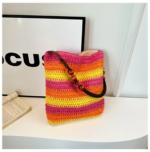 Detail of rainbow straw shoulder bag with colorful stripes and dark wooden bead handles