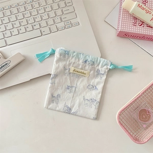 Close-up of small cotton drawstring pouch with cute blue cat print and soft fabric texture