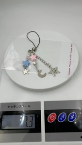 Y2K phone charm detail with pink and blue stars on a scale showing 7.3g weight