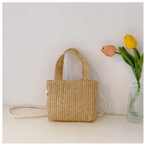 Detail of straw woven bag with fine diagonal weave texture and soft cotton shoulder strap