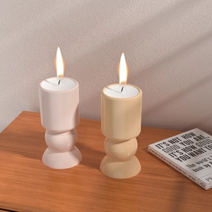 Detail von geometrischen Kerzenhaltern in Rosa und Beige auf einer Holzoberfläche