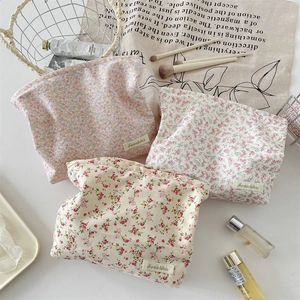 Detailed close-up of floral fabric makeup bags with vintage patterns and cloth labels