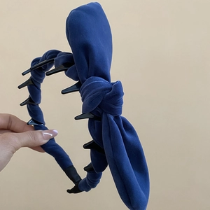 Detailed view of navy velvet headband featuring non-slip black inner teeth and thick sponge padding