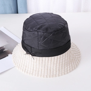 Detail of contrast bucket hat showing quilted diamond crown and corduroy brim with bow