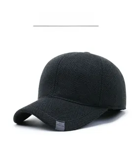 Detail of dark grey herringbone wool texture and metal plate on men's winter baseball cap