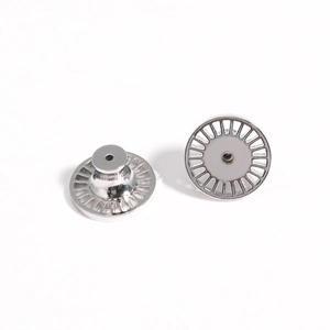 Macro shot of polished silver earring lifters showing center hole and radial texture