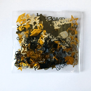 Detail of graduation confetti with gold stars, black mortarboards and silver GRAD letters