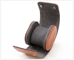 Detail view of brown leather watch travel case with gray velvet lining and snap closure