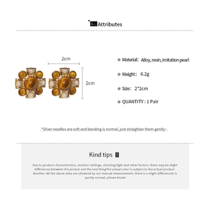 Detailed view of vintage flower-shaped pearl earrings with amber resin and alloy base