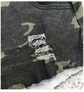 Detail der zerrissenen Camouflage-Jeansshorts mit ausgefranstem Saum und Distressed-Look