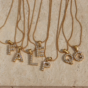 Detail view of gold 18K plated snake chain necklaces with zircon initial letter pendants