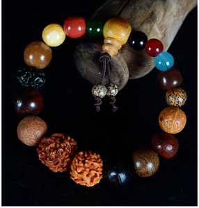 Detailed view of assorted Bodhi seeds and sandalwood beads on a dark wooden stand