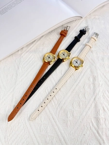 Three quartz watches with leather straps in brown, black, and white on a textured background